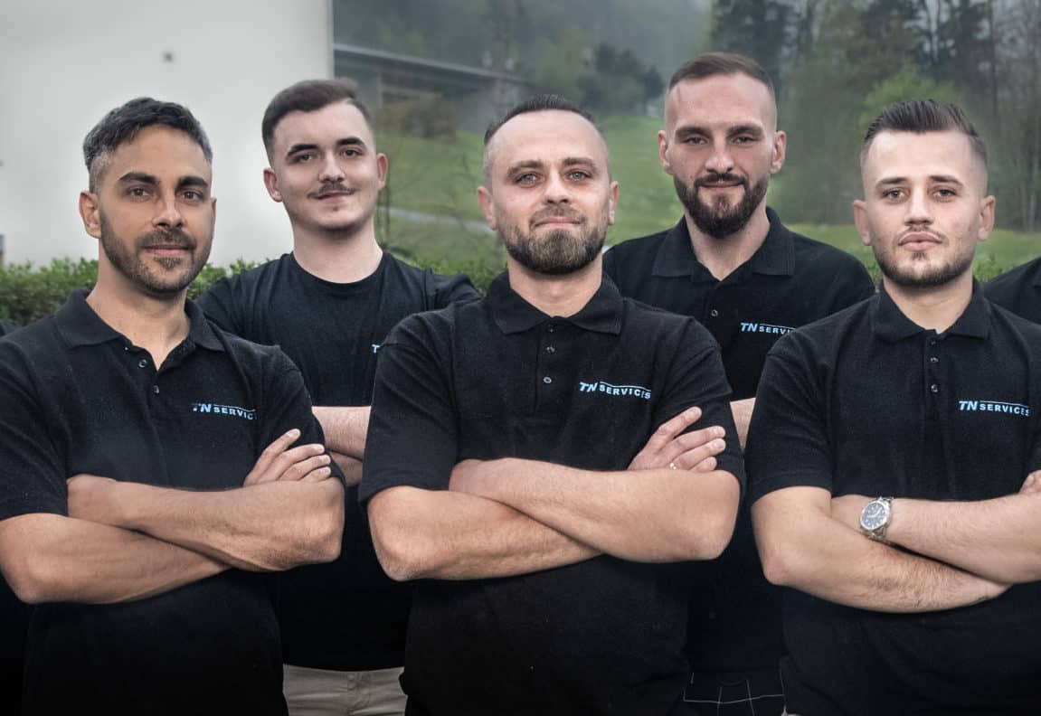 eine Gruppe von Männern, die nebeneinander stehen.